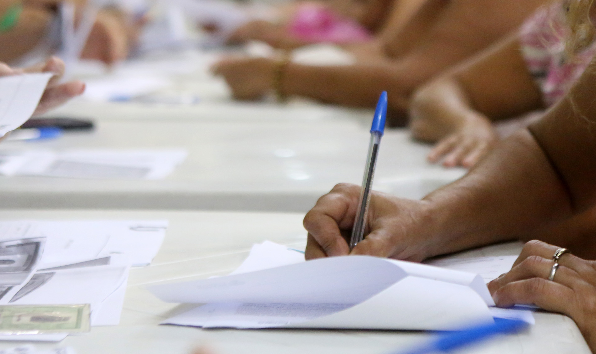 a foto mostra uma mão assinando um documento